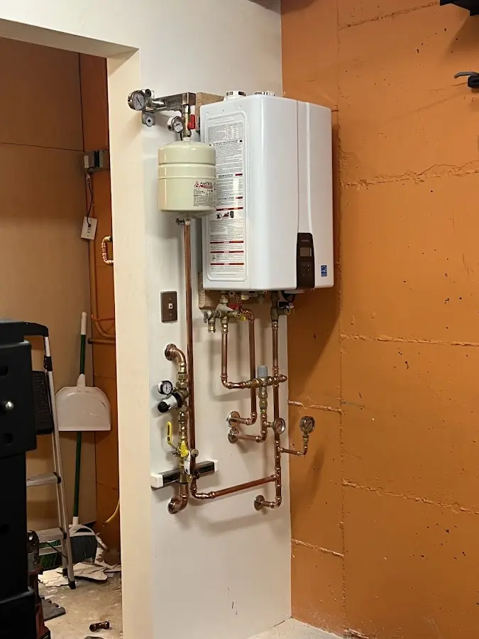 Plumbing technician inspecting water heater connections in Nacogdoches
